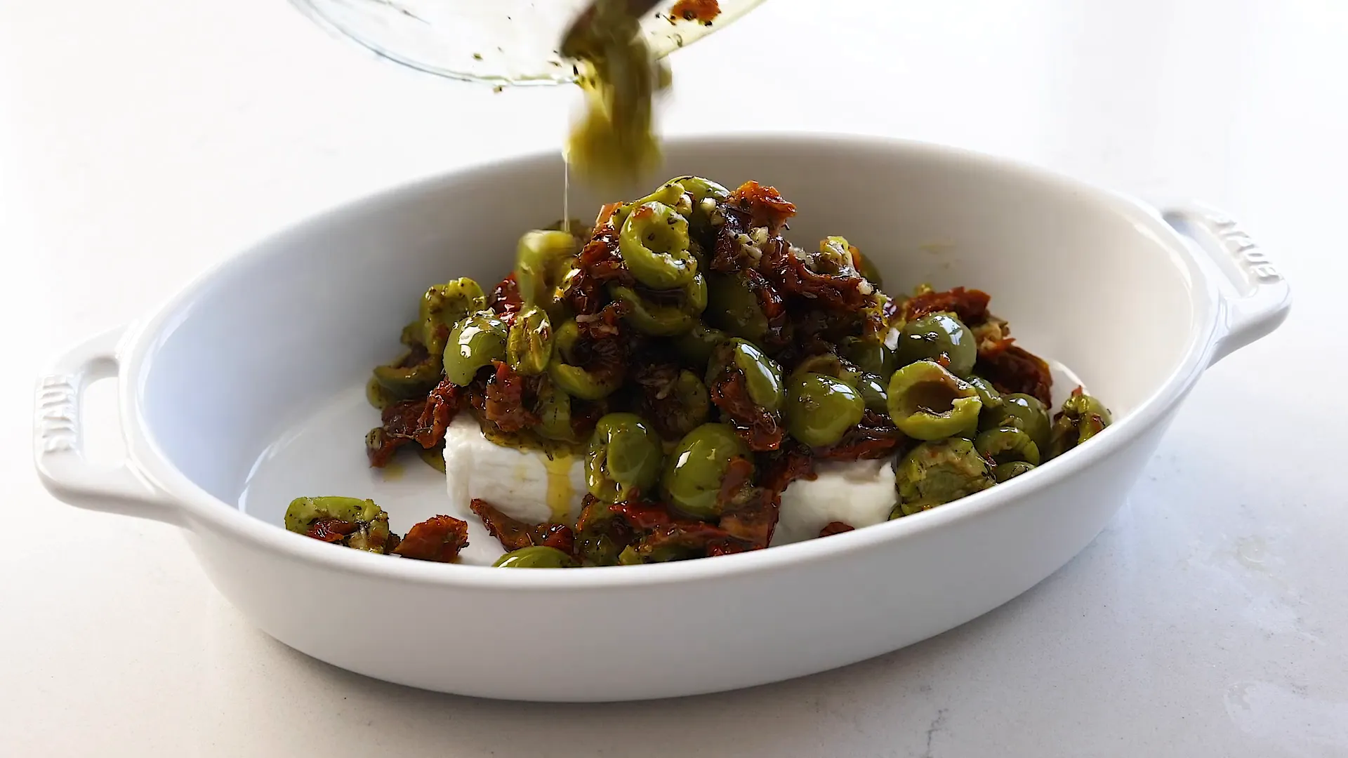 Pouring topping over feta.