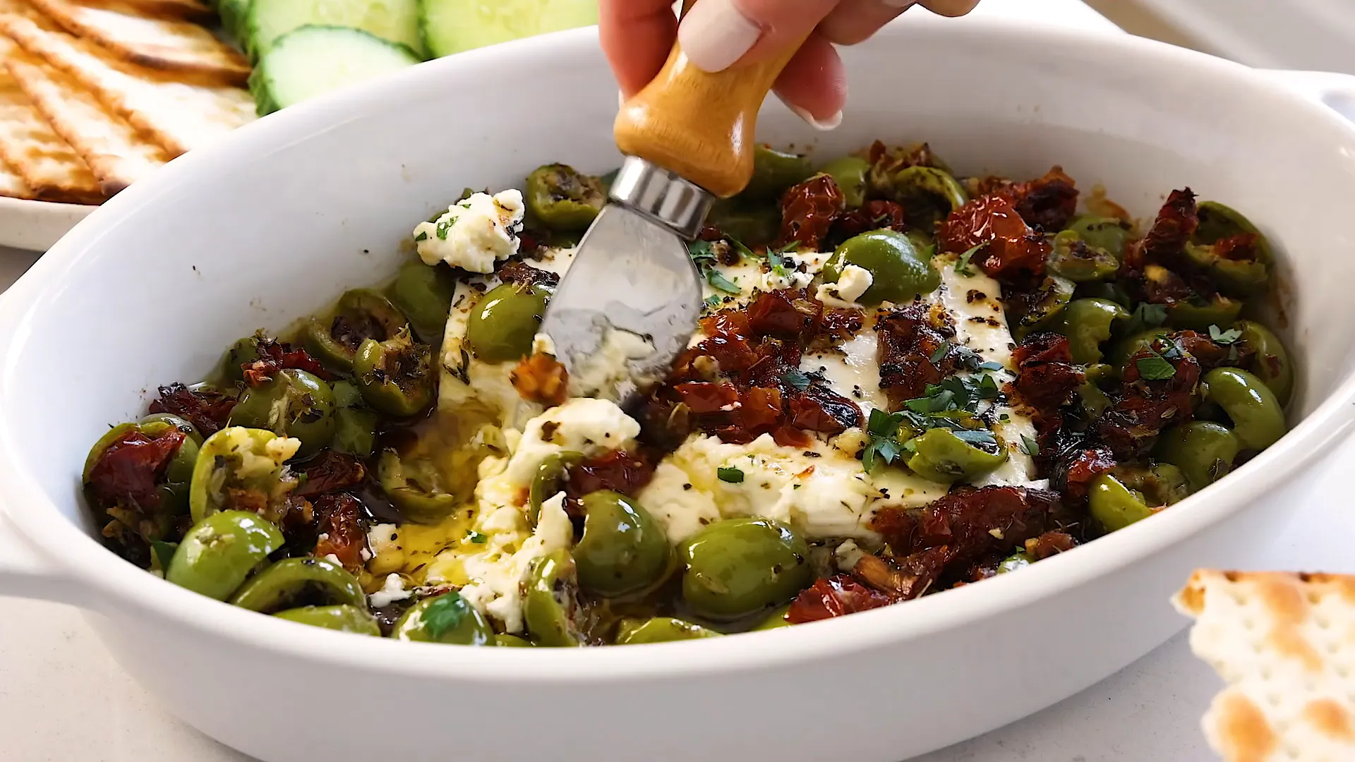 Serving baked feta with crackers.