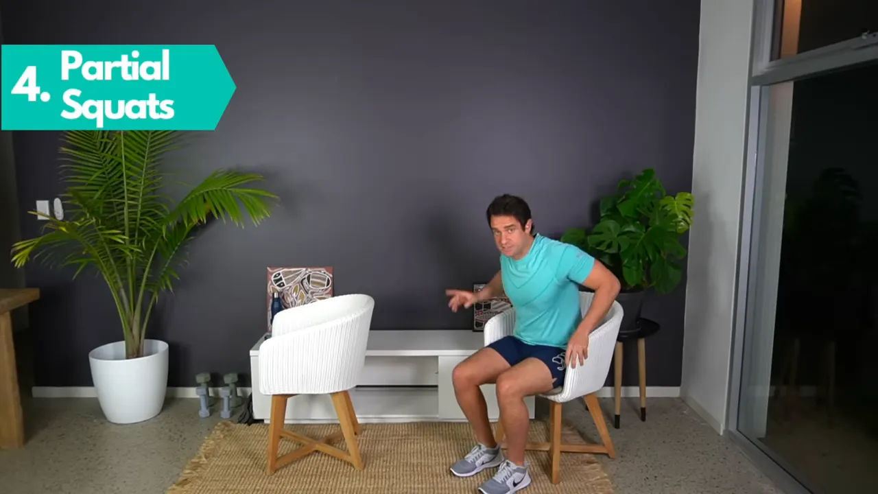 Standing partial squat behind a chair with on screen exercise label