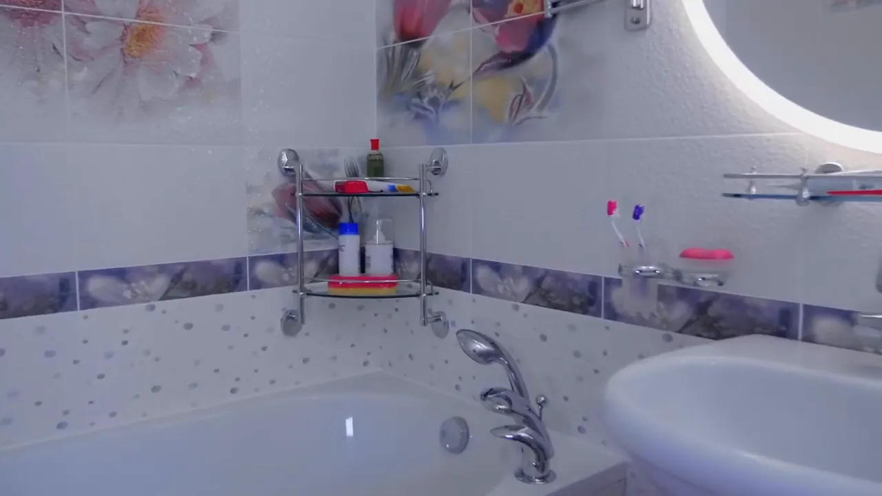 bathroom tub corner with wall shelf holding soap and bottles