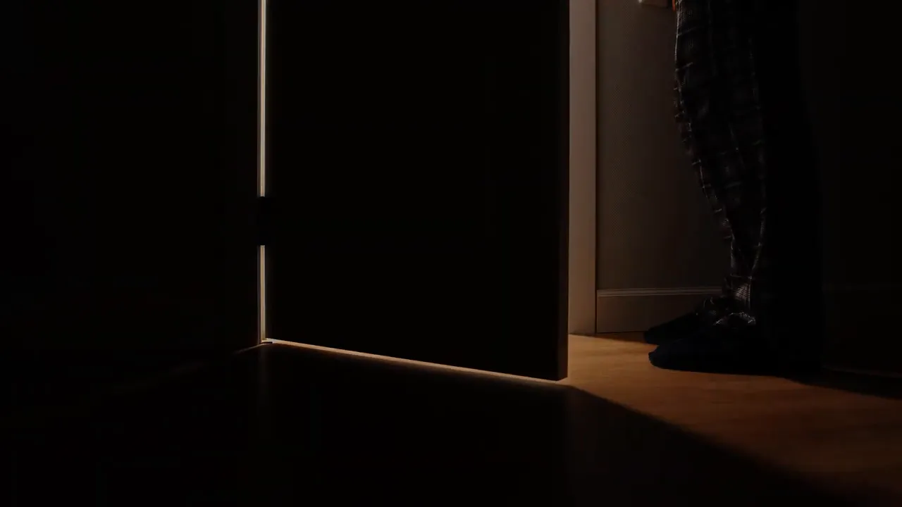 dark doorway opening into lit room at floor level