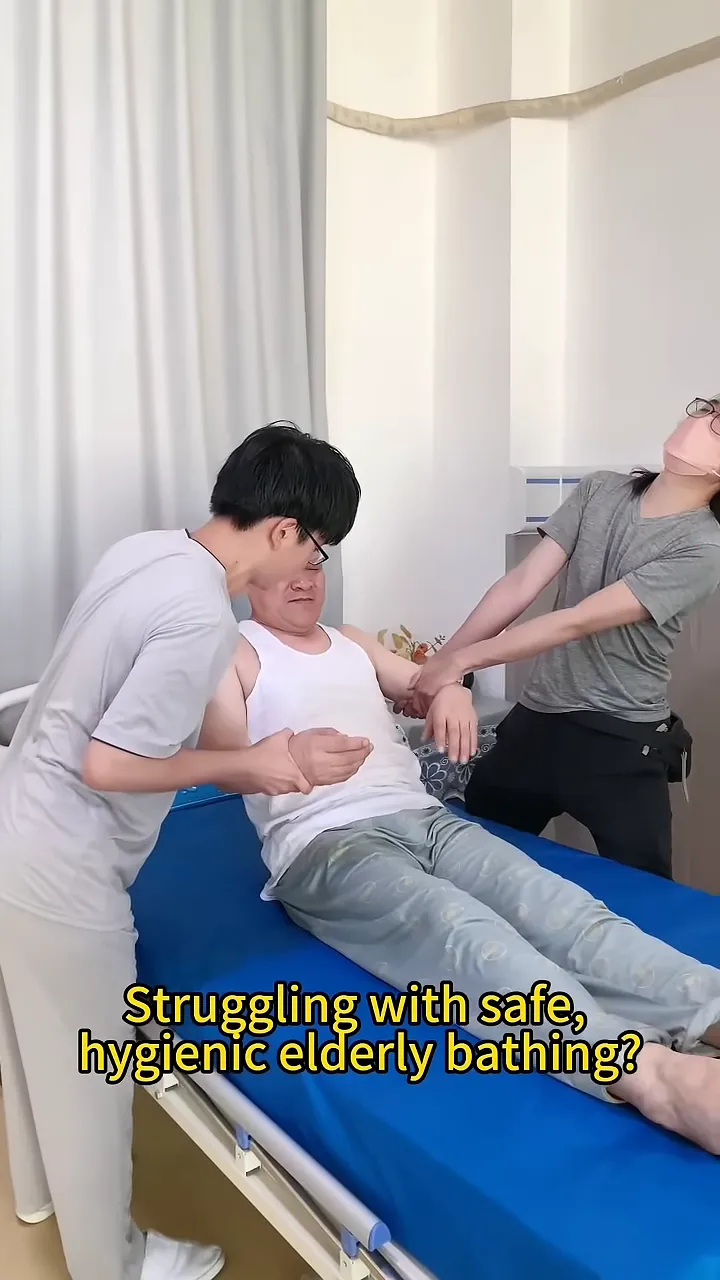 two caregivers helping a man sit up on a hospital bed
