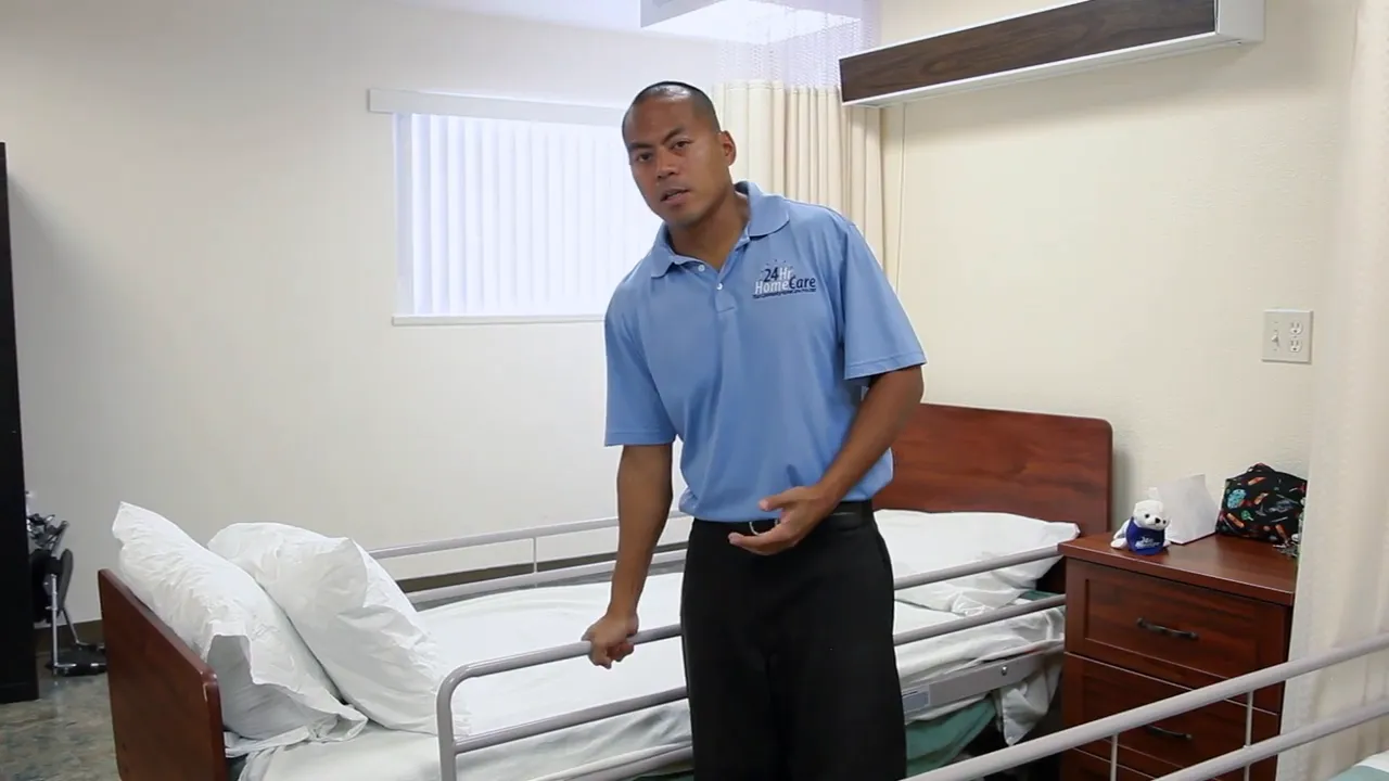 bed with metal side rail and person holding the rail beside it