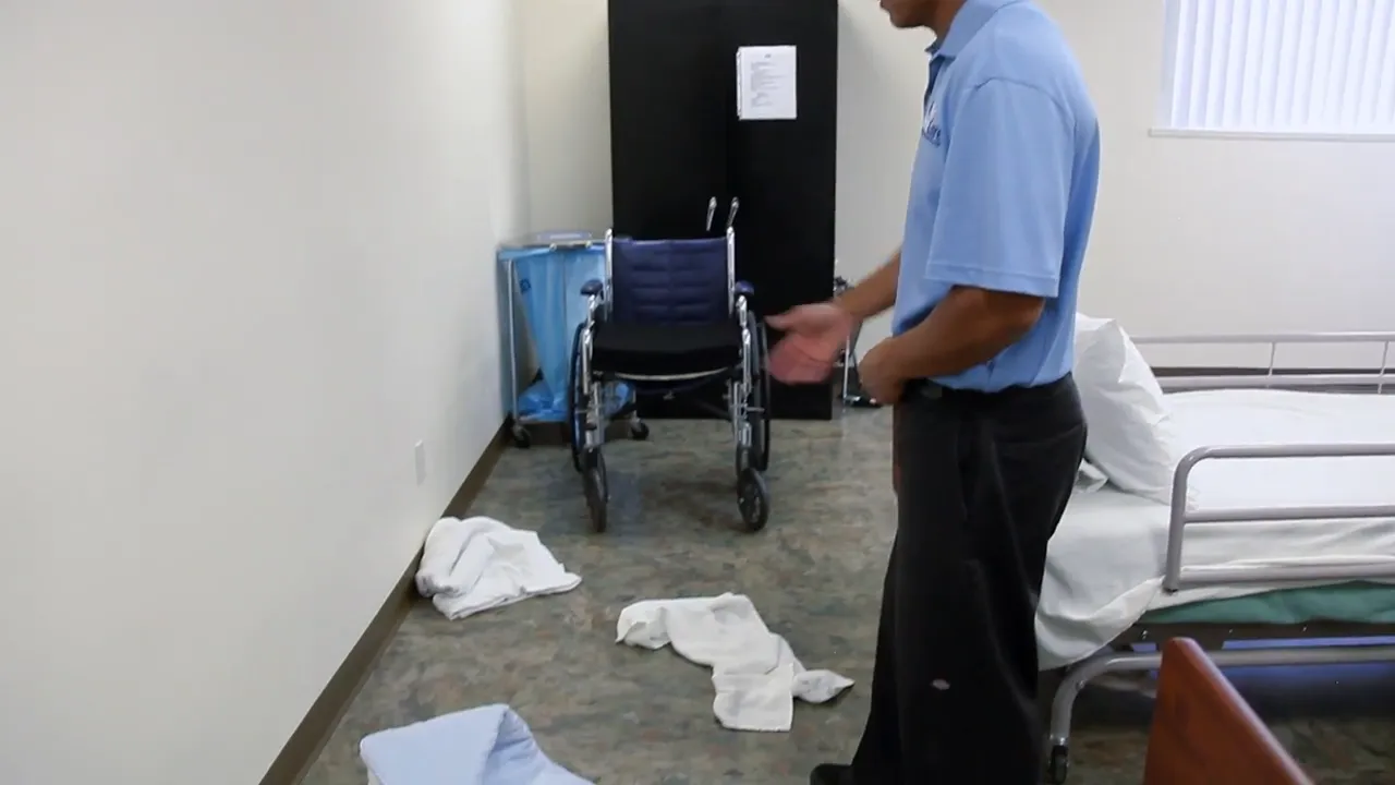 floor walkway beside beds with linens and clothing scattered on the ground