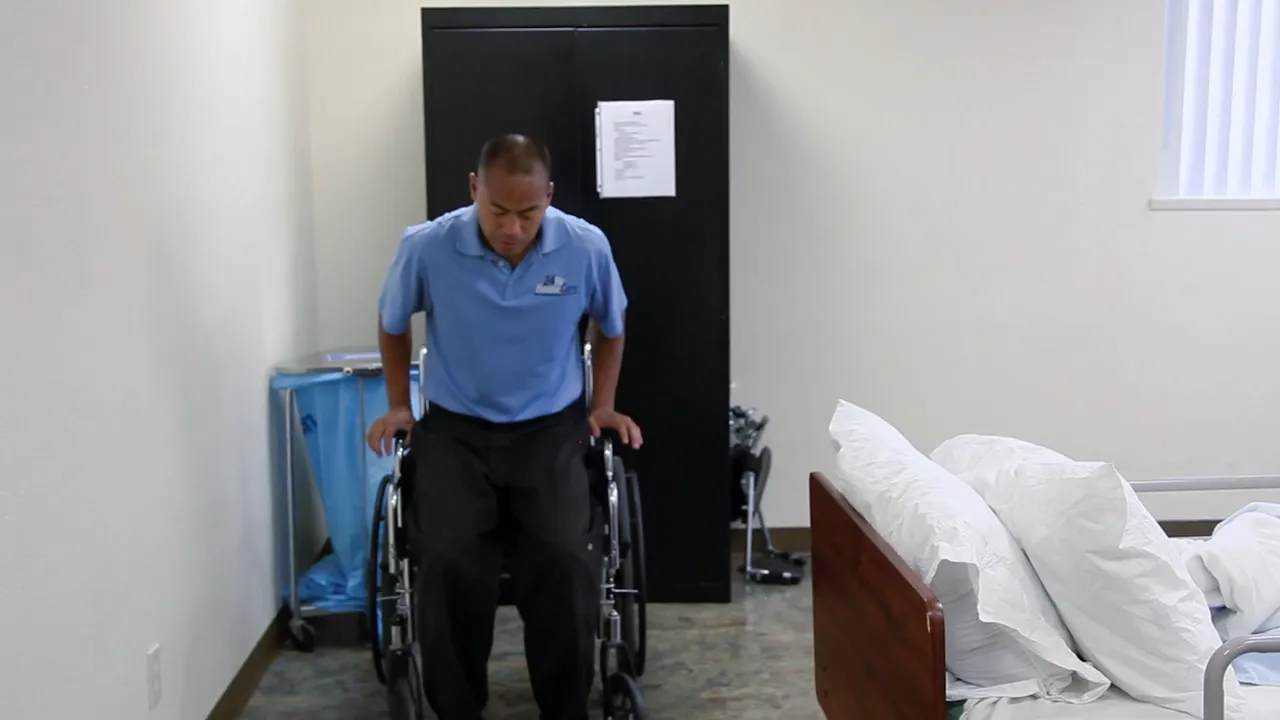 person seated in wheelchair with hands on armrests in a care room