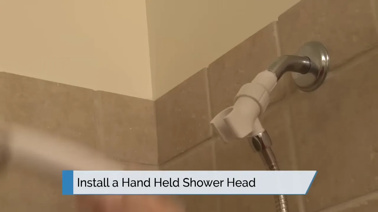 hand holding a handheld shower head near shower pipe with on screen text install a hand held shower head