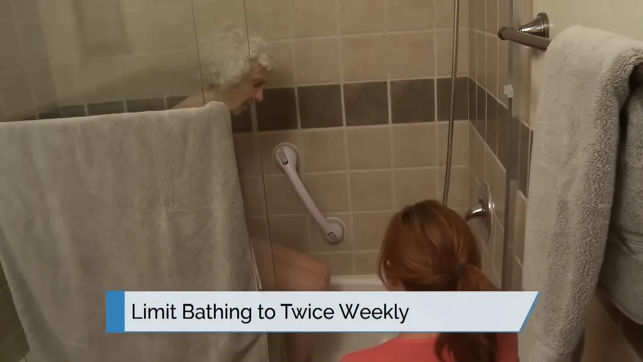 caregiver assisting person in bathtub with on screen text limit bathing to twice weekly