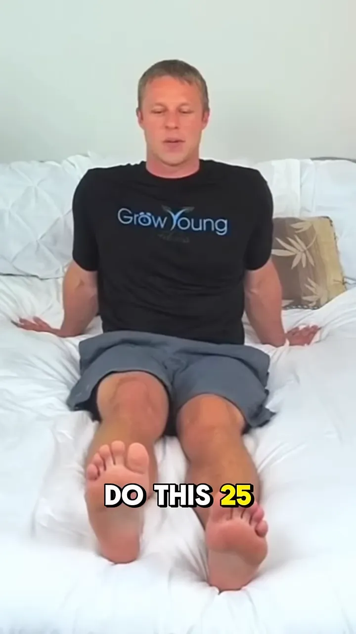 person seated on a bed lifting one leg upward