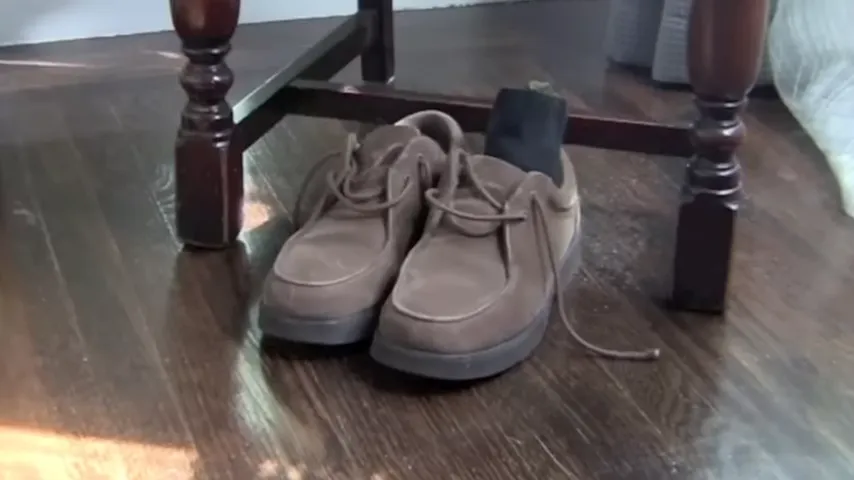 Pair of low-cut shoes on a wood floor beside a chair