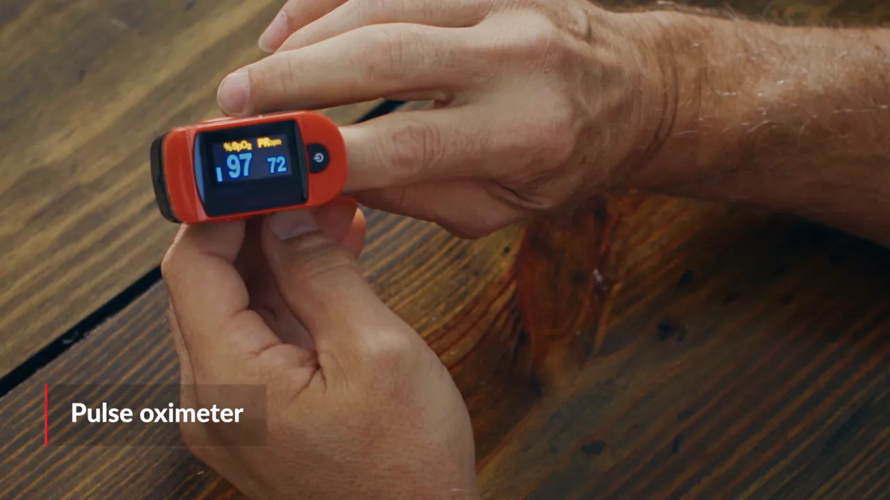 Close-up of a fingertip pulse oximeter displaying oxygen saturation and pulse readings