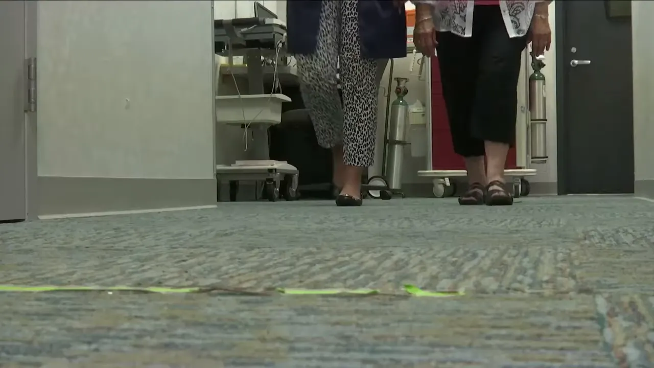 close view of two people walking down a clinic hallway over a marked floor path