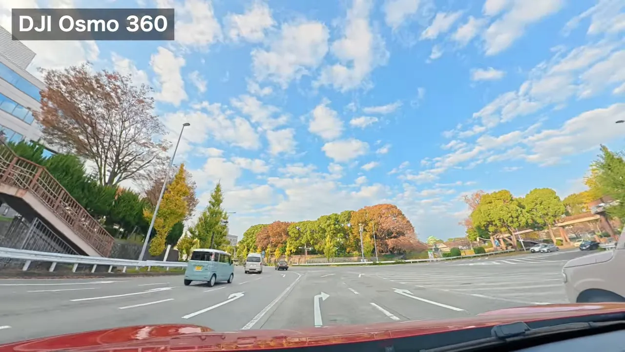 DJI Osmo360で撮影した名古屋城周辺の昼景、広い青空と遠景の木立が中央に見える車載写真