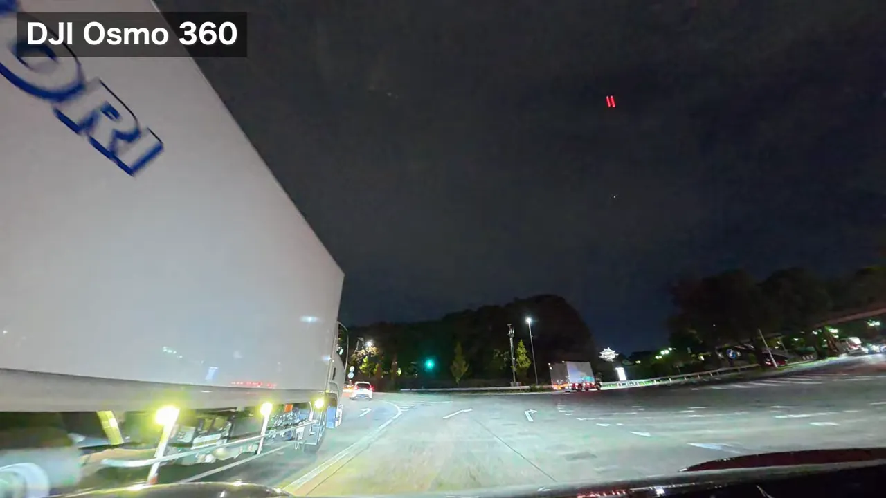 DJI Osmo 360で撮影した名古屋城周辺の夜景。遠方にライトアップされた城が見える車載映像。トラックと道路の前景あり。