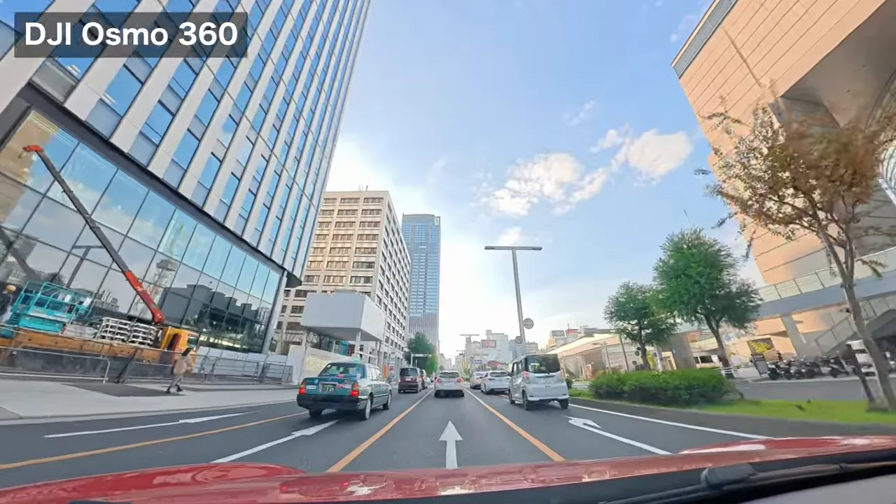 Osmo360による栄エリア昼間の車載ショット、明るい青空と遠景のビルが鮮明に見える
