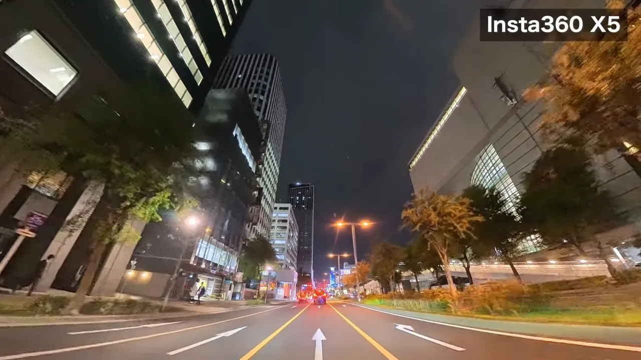 Insta360 X5で撮影した夜の名古屋市街地の車載映像、中央に走行車線と両側の高層ビルが見える