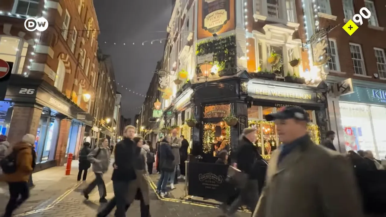 Londra'da kalabalık sokak ve ışıklı pub dış cephesi