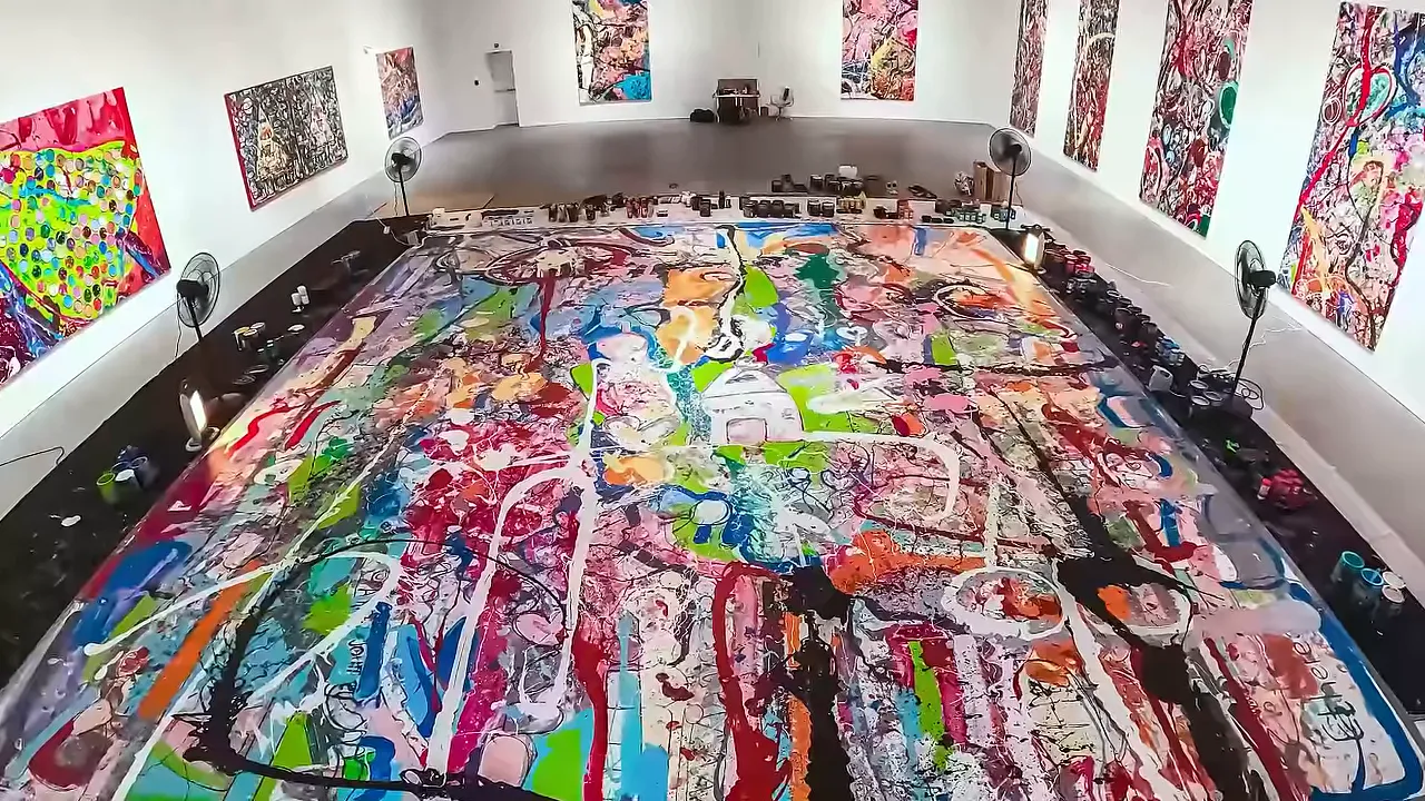 Studio Jafri large colorful canvas laid out on gallery floor surrounded by tools and paintings on the walls