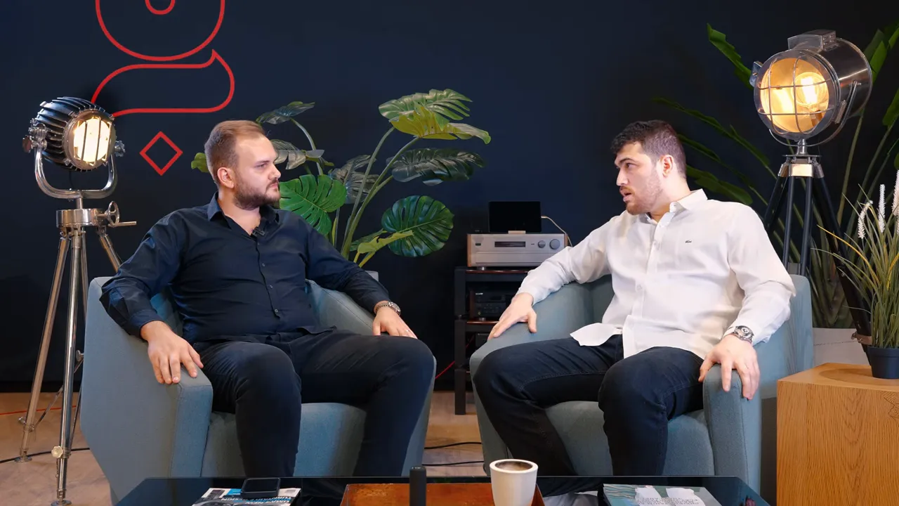 İki kişi st&uuml;dyo koltuklarında oturuyor, Dubai'de oturum izinleri hakkında konuşuyorlar.