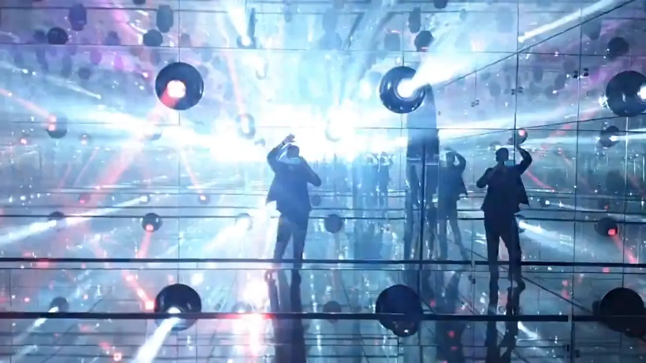 Visitors viewing an immersive mirrored light installation with suspended elements in a contemporary gallery