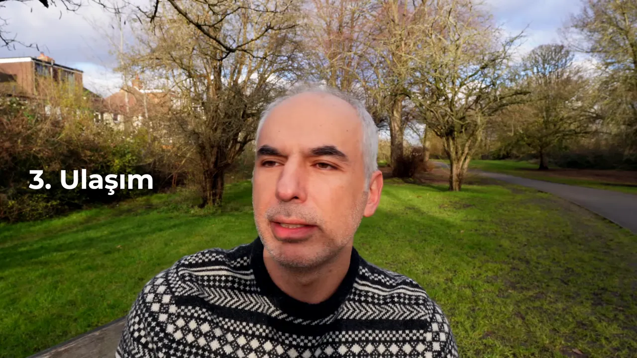 Parkta oturan konuşmacı, solda b&uuml;y&uuml;k beyaz yazıyla '3. Ulaşım' başlığı g&ouml;r&uuml;n&uuml;yor.