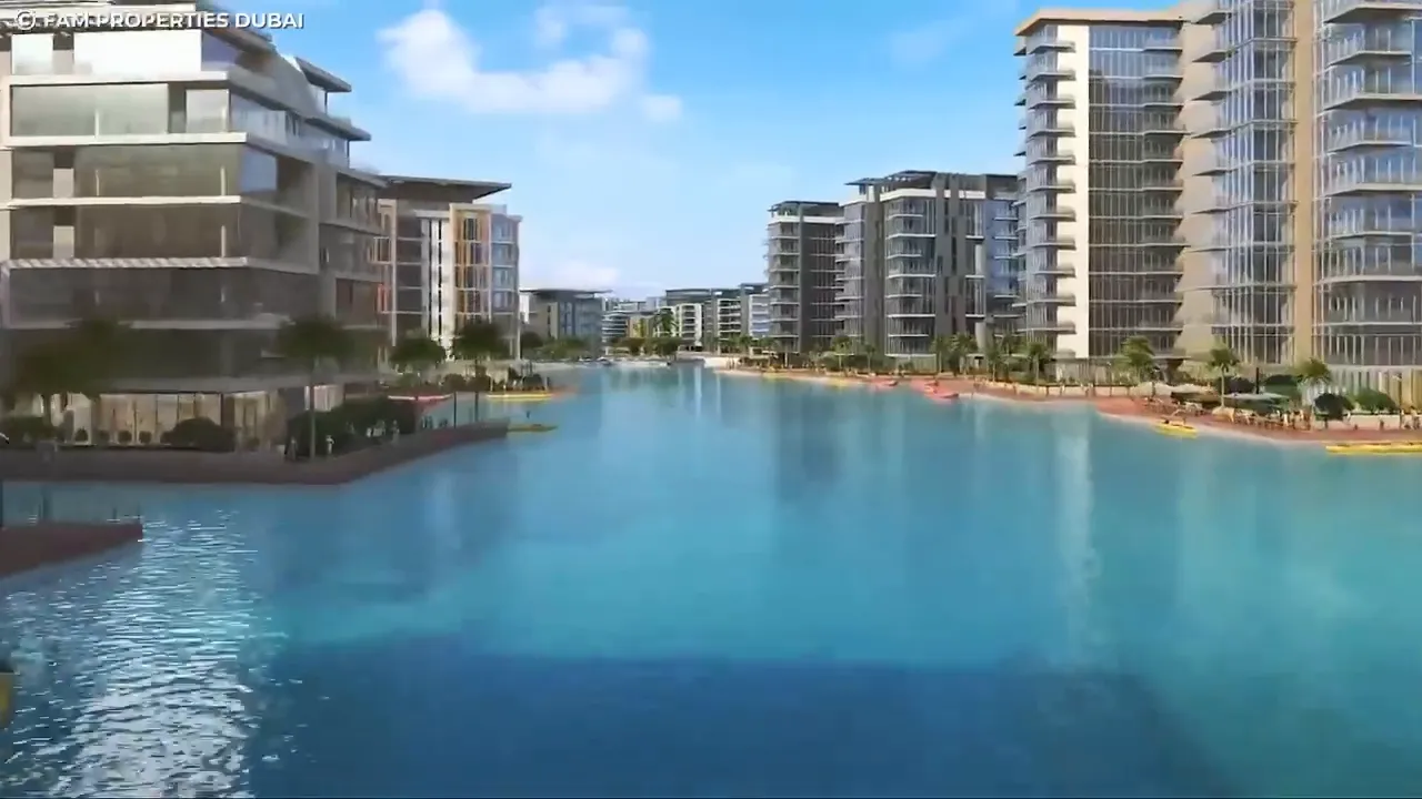 Modern waterfront residential development with a wide blue lagoon and multiple mid-rise buildings
