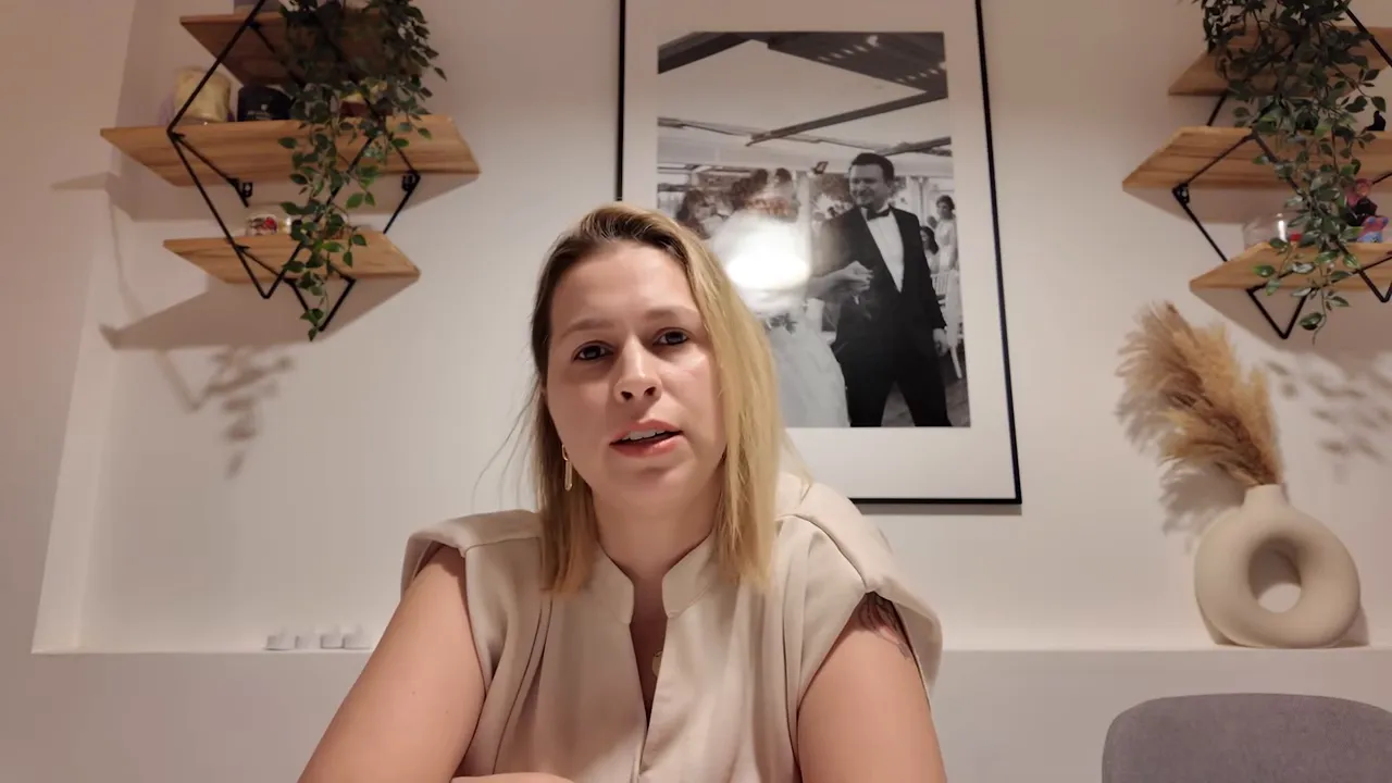 Anlatıcı kameraya bakıyor, arka planda duvar resmi ve dekoratif raflar net şekilde g&ouml;r&uuml;n&uuml;yor