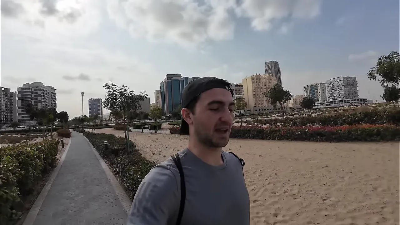 Dubai'de y&uuml;r&uuml;y&uuml;ş yolu, kumluk zemin, ağa&ccedil;lar ve şehir binaları