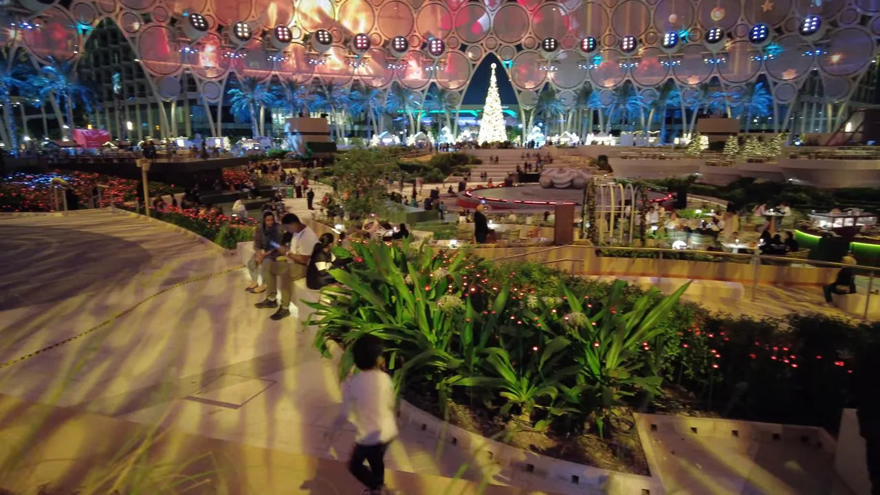 Family area at Expo City Winter City with Christmas tree, children running and groups seated