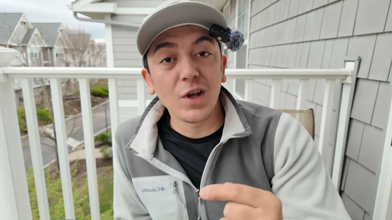 Ehliyet ve ride‑share kurallarını anlatan kişi, şapka ve mikrofonla balkon &ouml;n&uuml;nde