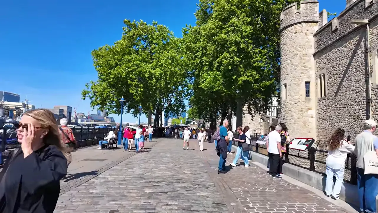 Tower of London kenarındaki yaya yolu, turistler ve ağa&ccedil;larla dolu geniş a&ccedil;ı g&ouml;r&uuml;nt&uuml;