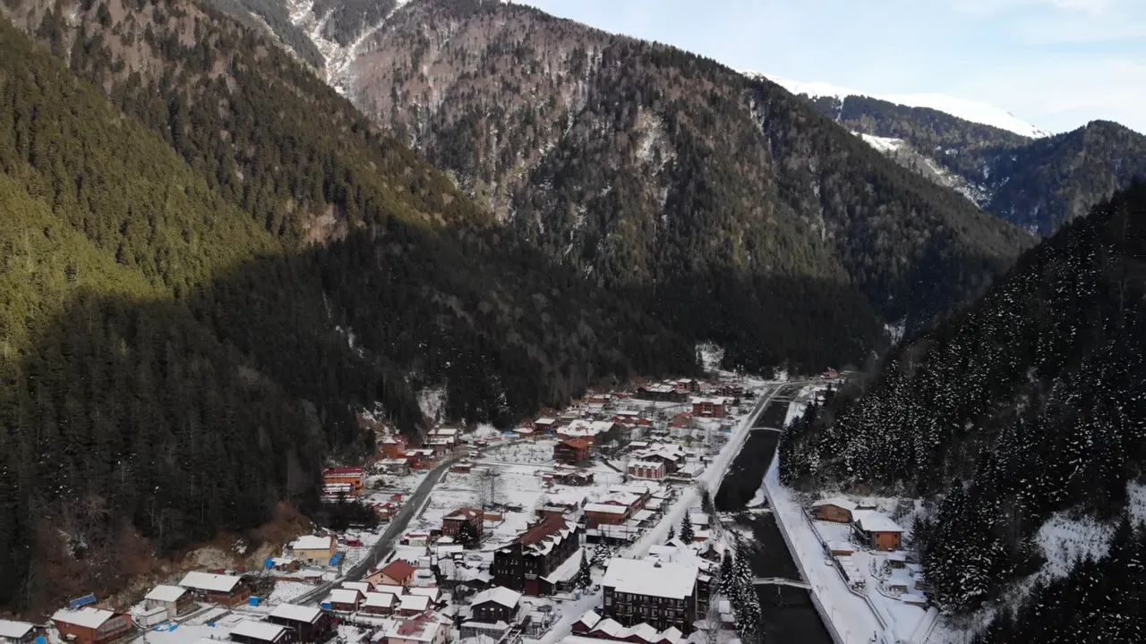 Kar kaplı Uzungöl vadisi, göl çevresindeki evler ve etrafı saran ormanlı dağlar