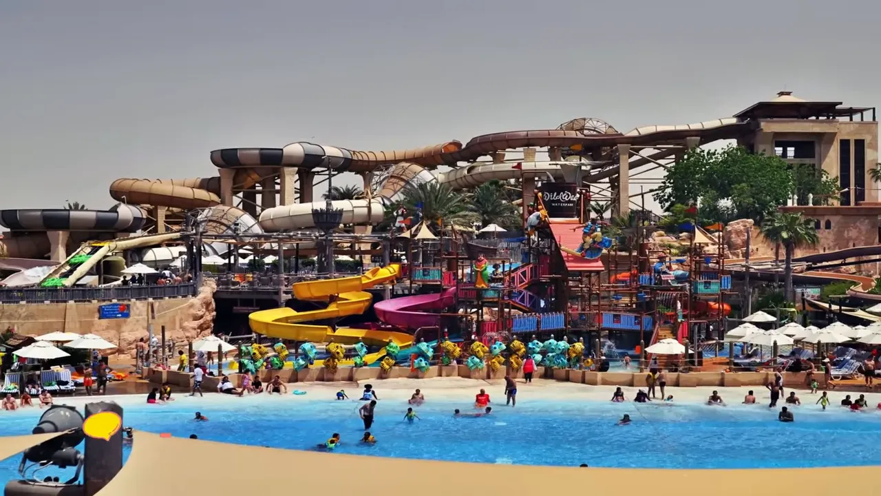 Wide view of a waterpark showing multiple twisting slides, a children's play structure and a busy wave pool