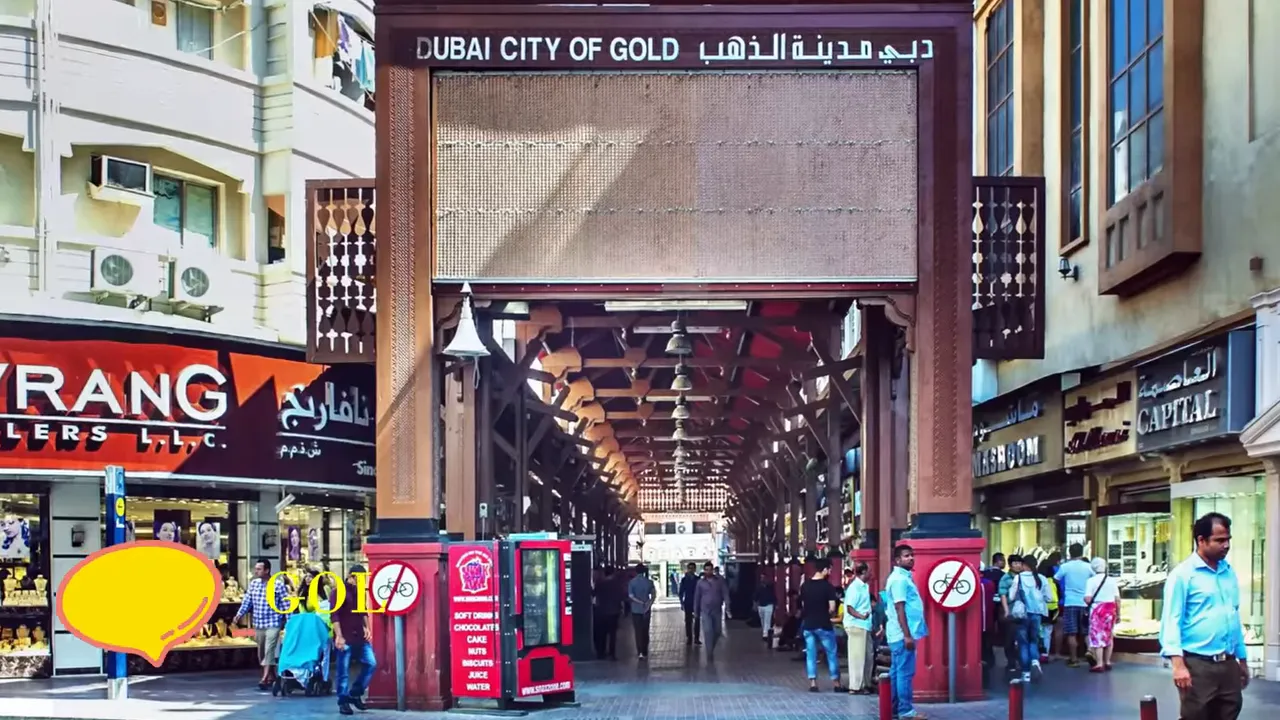 Archway entrance reading 'Dubai City of Gold' with the covered market corridor of the Gold Souk and shoppers