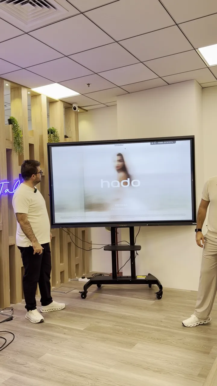 Ekranda 'hado' logosu ve marka g&ouml;rseli g&ouml;sterilen sunum sahnesi