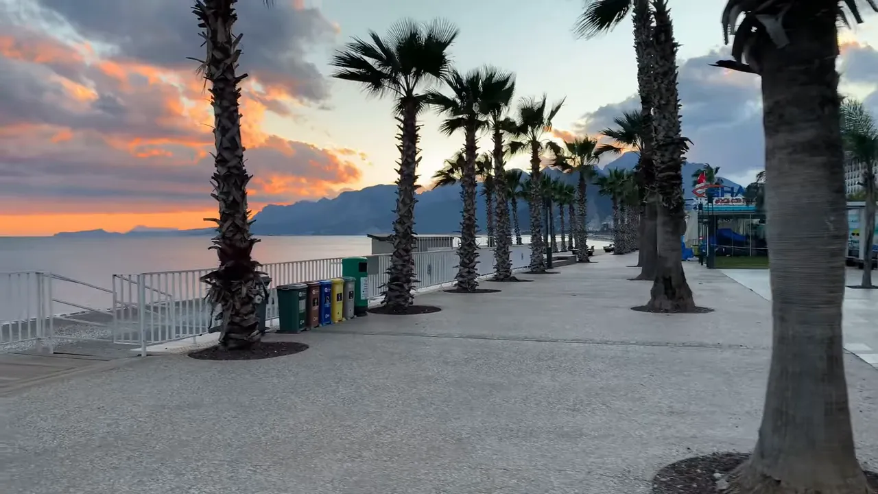 Antalya marina promenade with palm trees at sunrise, empty seaside walkway