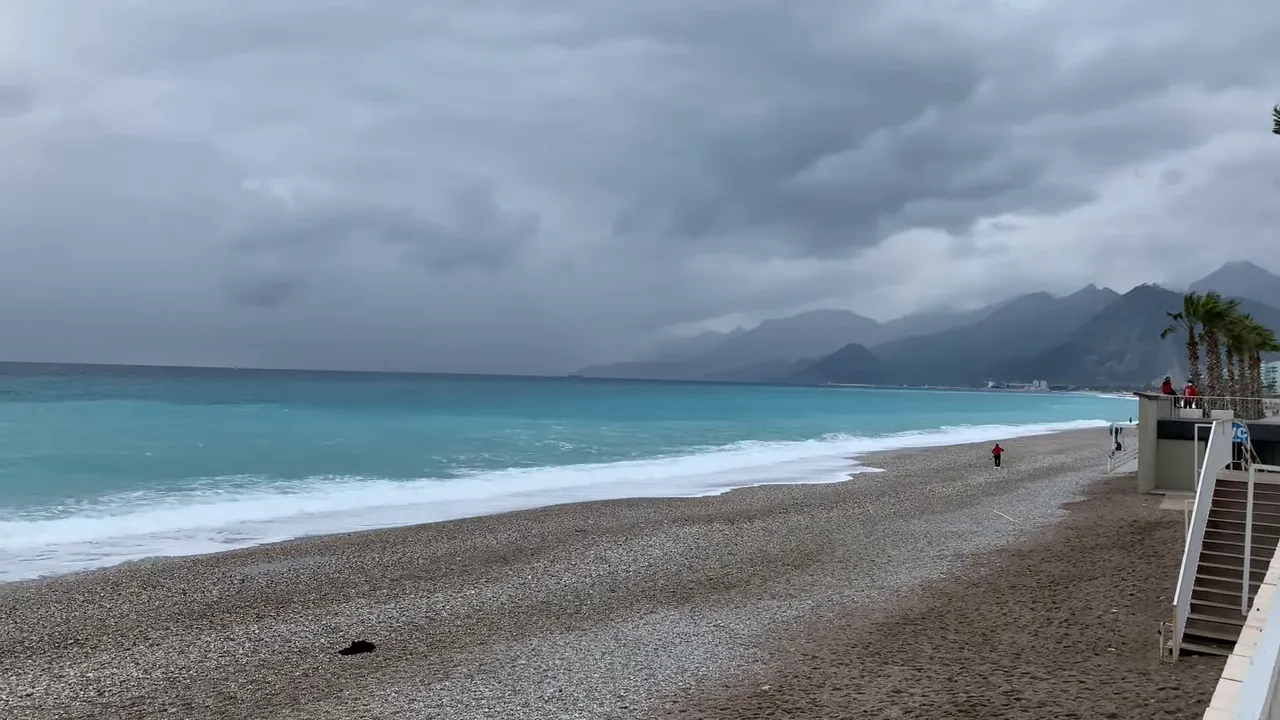 Wide pebble beach and mountain coastline in Antalya with an empty winter shore