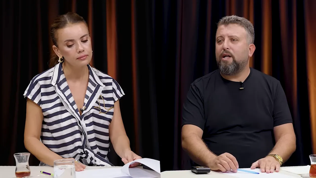 İki sunucu stüdyo çekiminde; erkek sunucu konuşuyor, kadın sunucu dinliyor; net ve iyi aydınlatılmış görüntü.