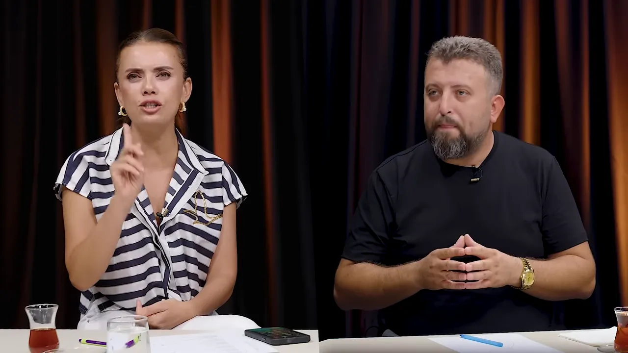 Stüdyoda bir konuşmacı elini kaldırarak vurgulama yapıyor, diğeri dinliyor