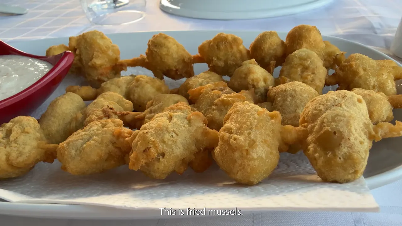 Fried mussels served on a plate with sauce dish