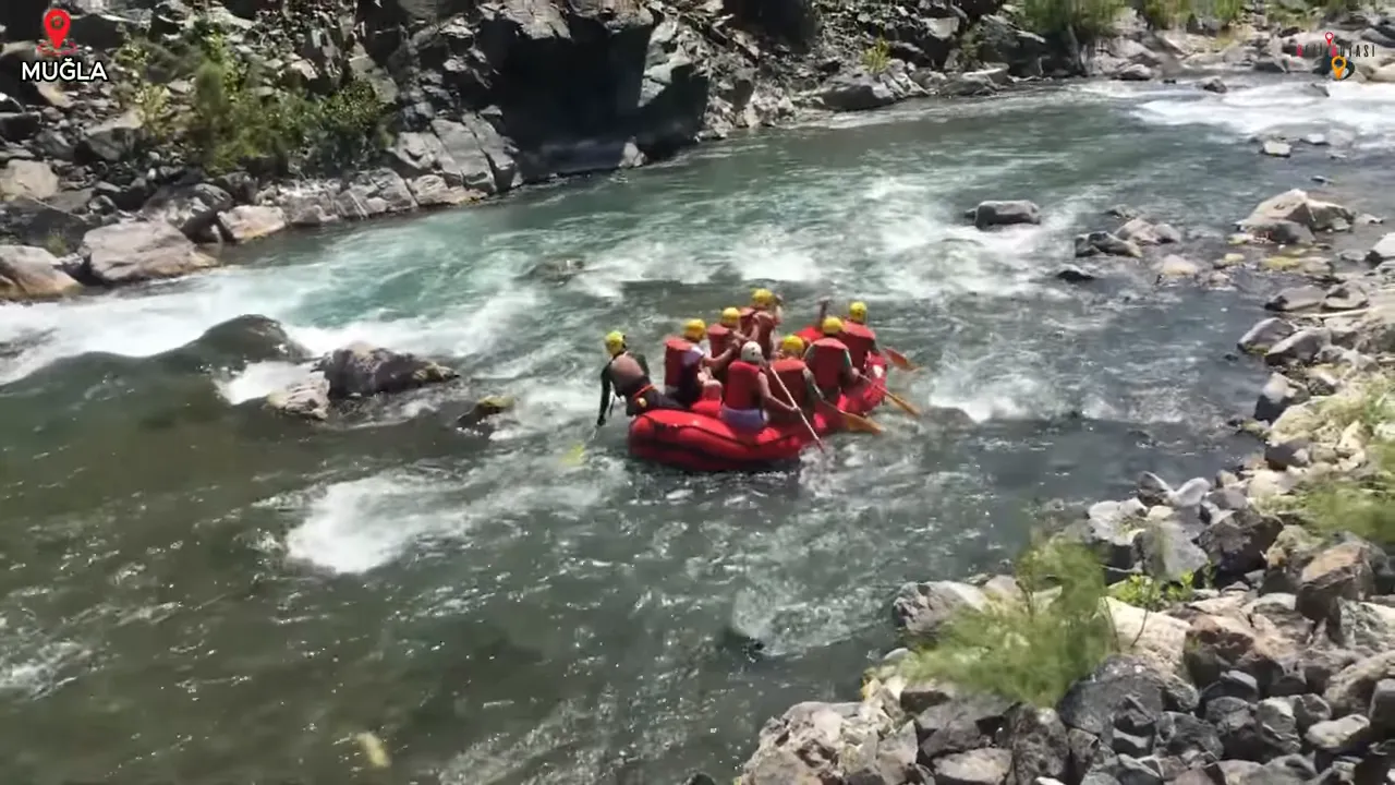 Dalaman Çayı'nda rafting botu taşlı kıyılar ve hızlı akan su ile