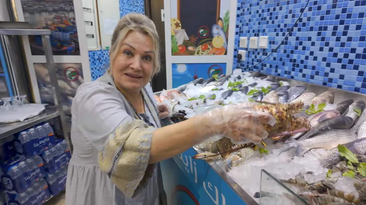 Buz &uuml;zerinde dizilmiş taze balıklar ve tezg&acirc;htan balık se&ccedil;en sunucu