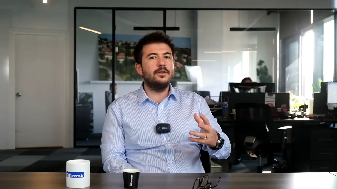 Well-lit mid-shot of presenter gesturing while speaking in an office, coffee cups and glasses on the table