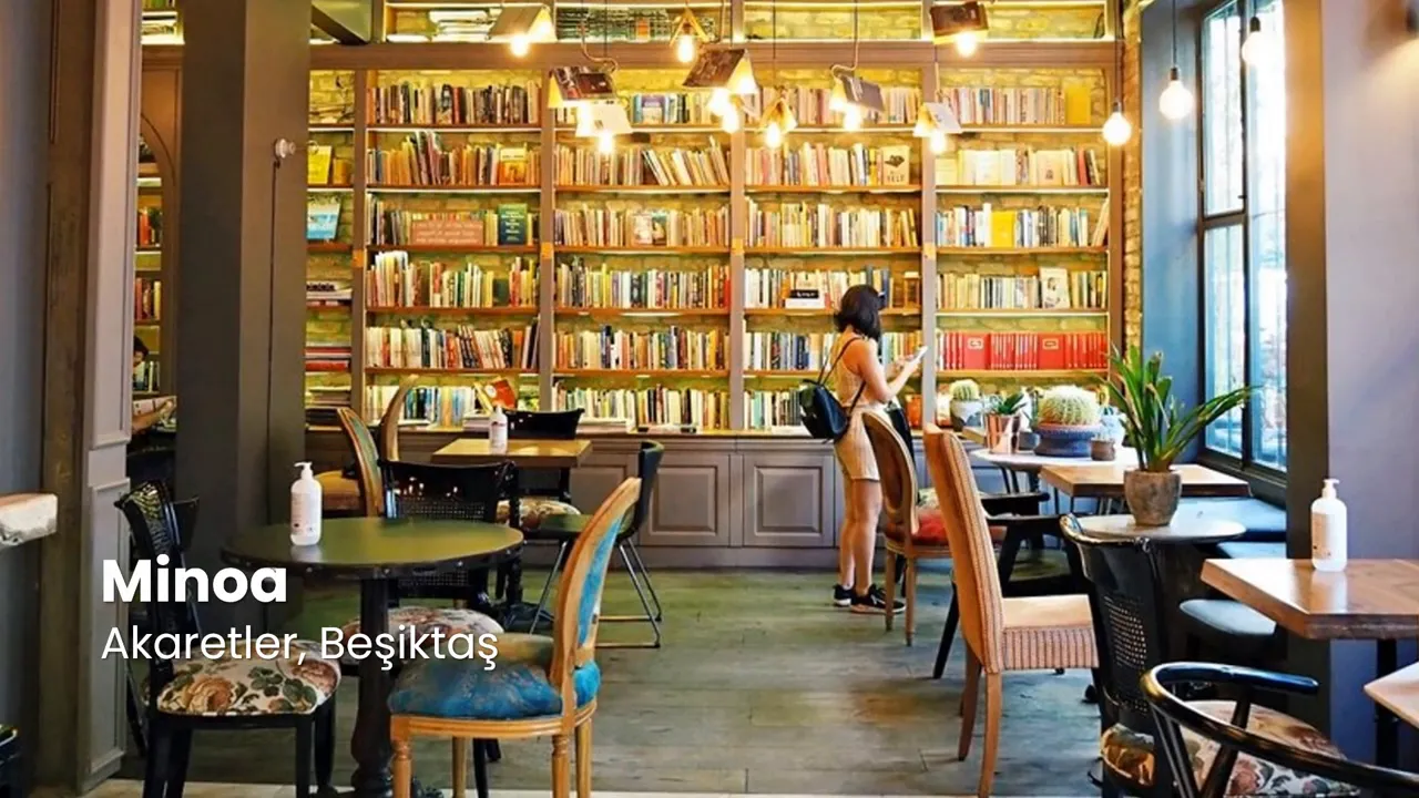Cozy interior of a book-lined caf&eacute; with tables, chairs and warm hanging lights