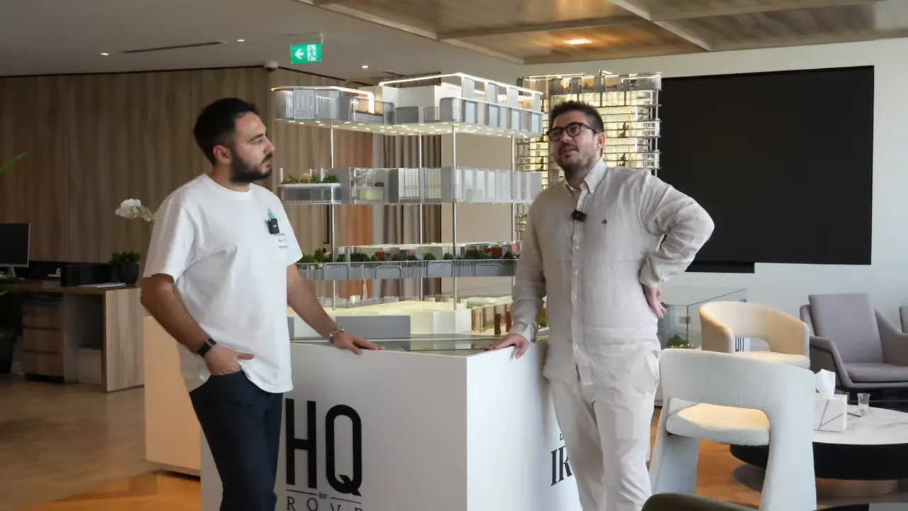 İki konuşmacı proje maketi &ouml;n&uuml;nde duruyor; maketin detayları ve ortak alanlar net şekilde g&ouml;r&uuml;lebiliyor.