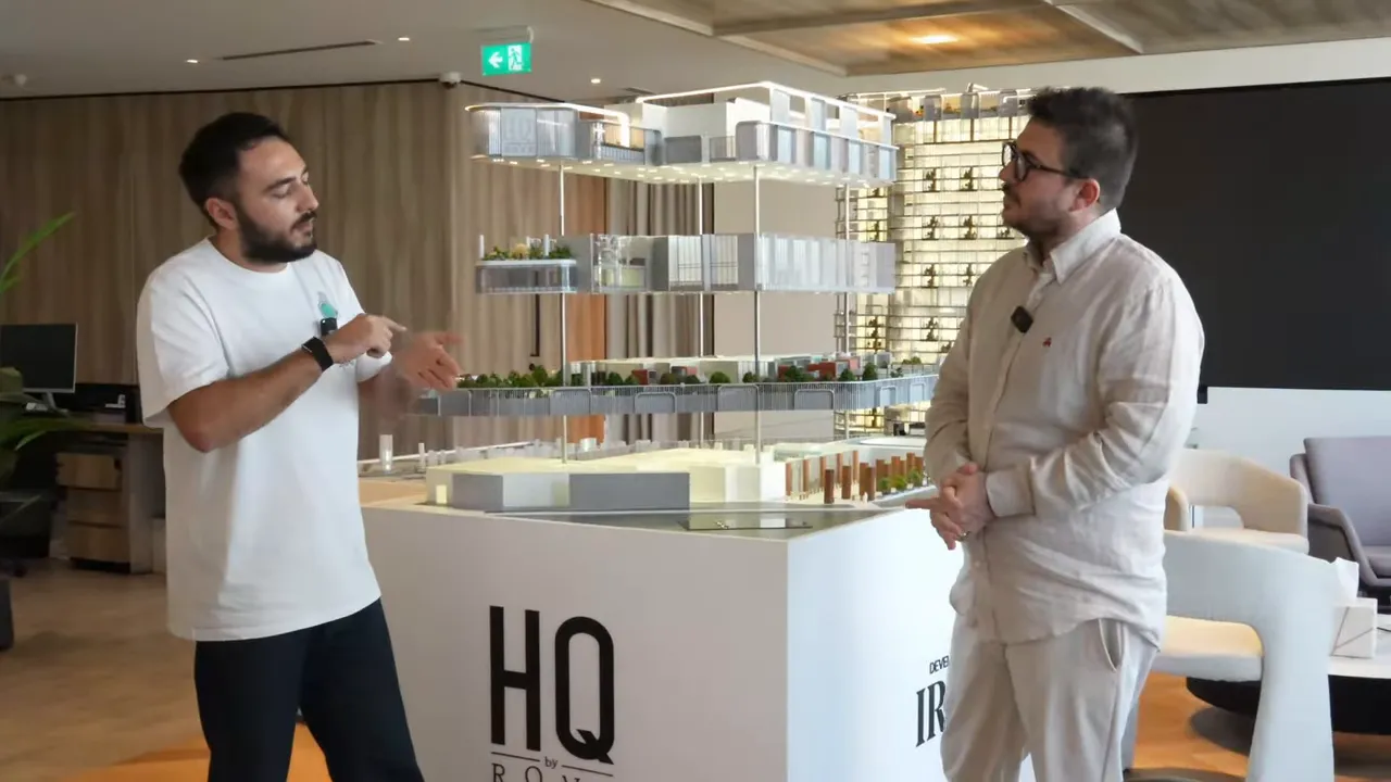 ROW HQ bina maketi &ouml;n&uuml;nde iki konuşmacı, maketin detayları net ve merkezde.