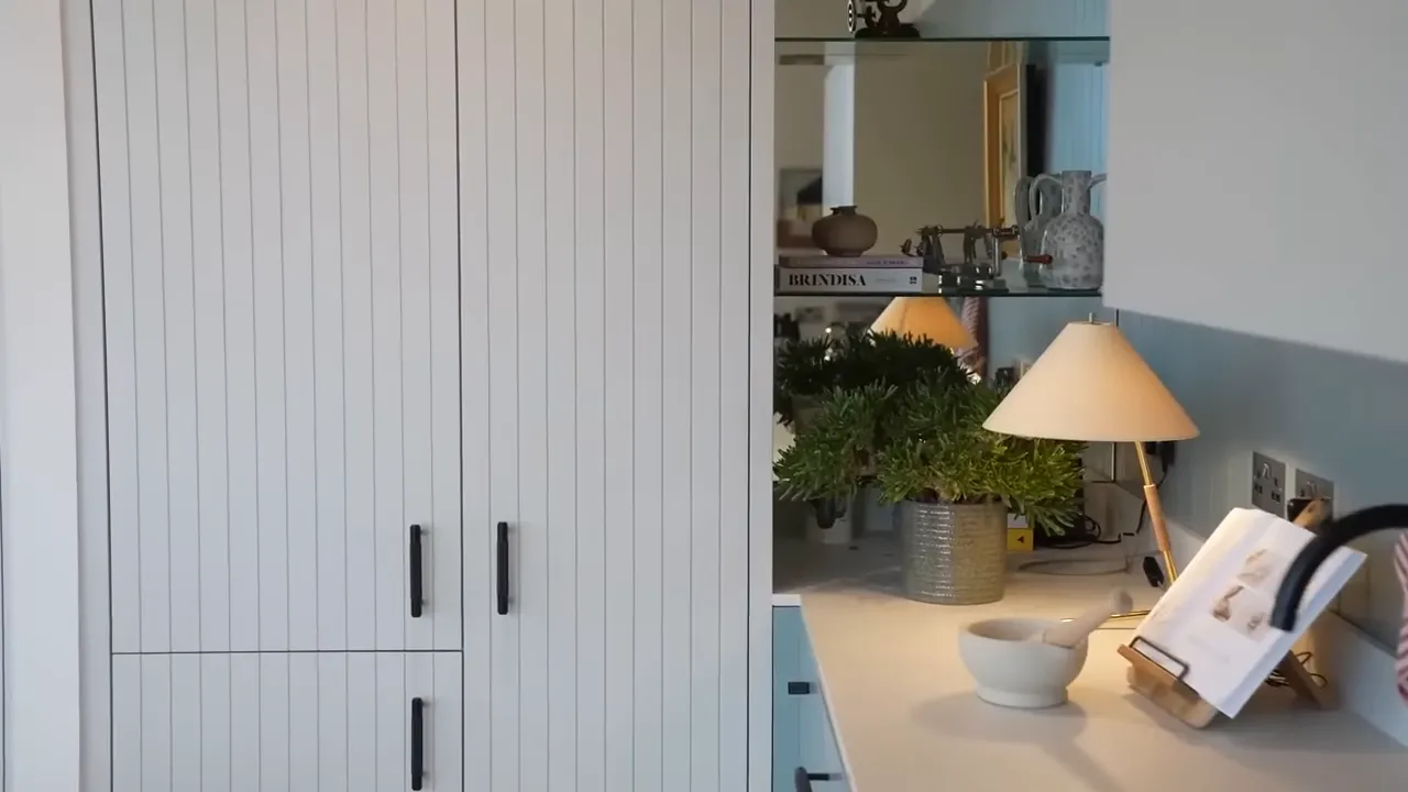 Mutfak tezgahı, dolap kapakları, lamba ve dekoratif bitki