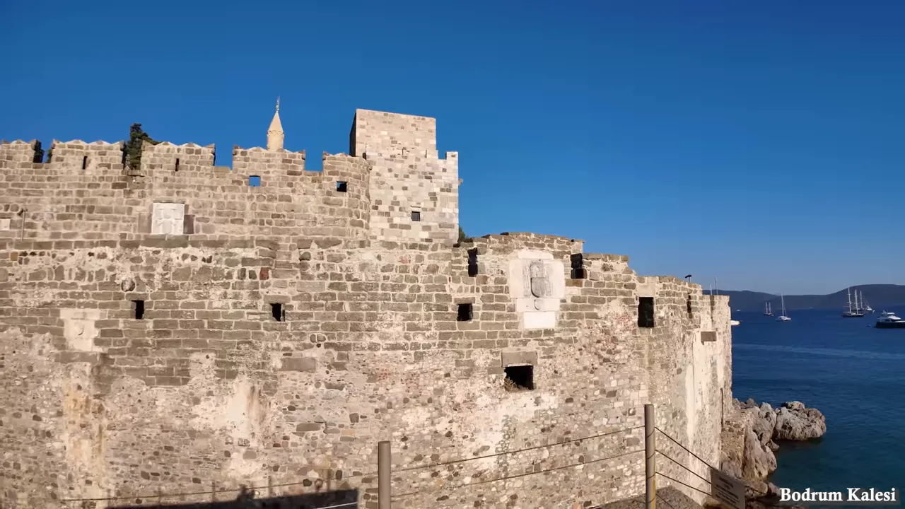Bodrum Kalesi duvarı ve hemen dışında mavi Ege denizi ile demirlemiş tekneler