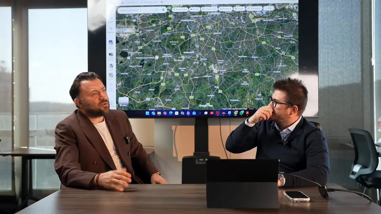 Londra haritası ekranı &ouml;n&uuml;nde iki kişinin emlak yatırım b&ouml;lgelerini tartışması