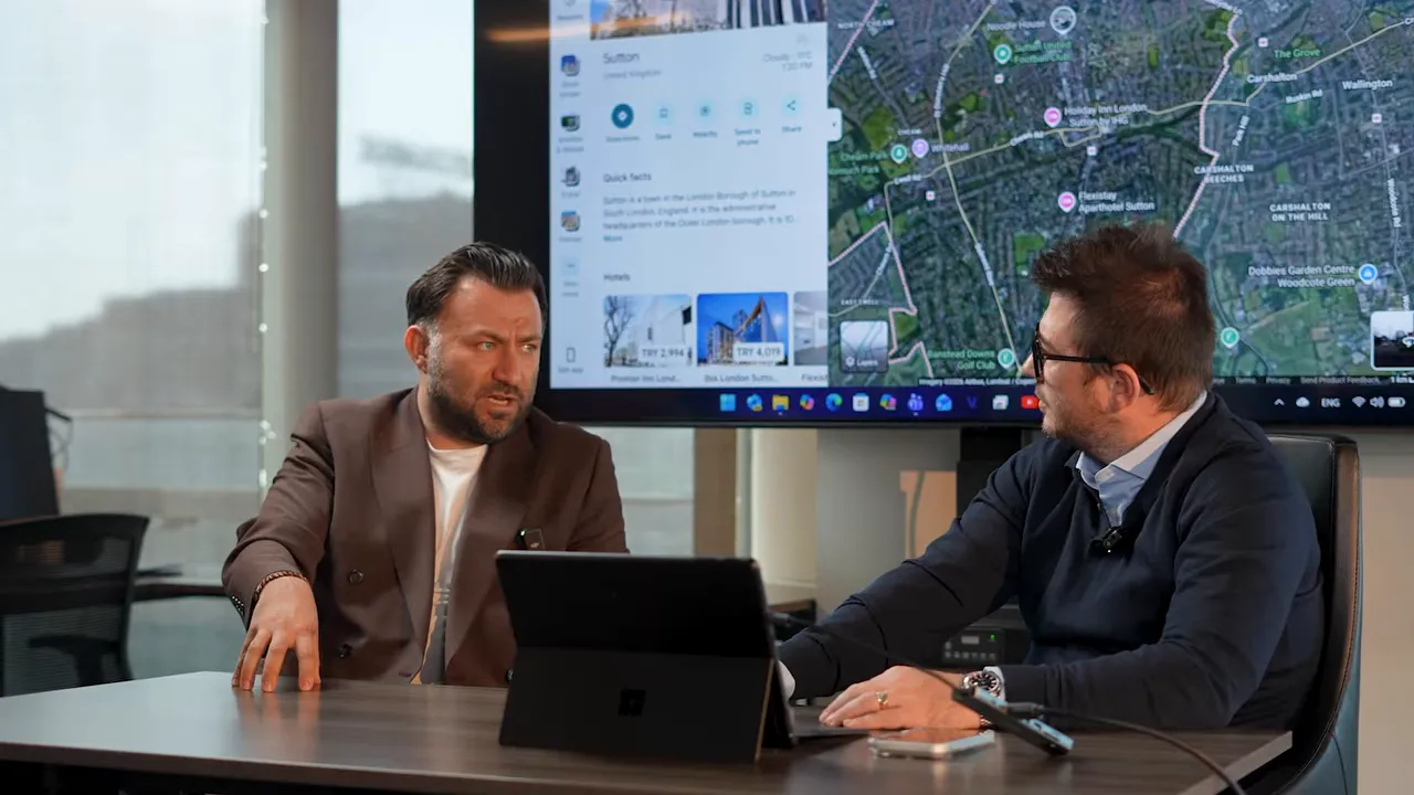 Londra b&ouml;lgesi haritası ekranda g&ouml;r&uuml;n&uuml;rken iki yatırım danışmanı g&ouml;r&uuml;ş&uuml;rken