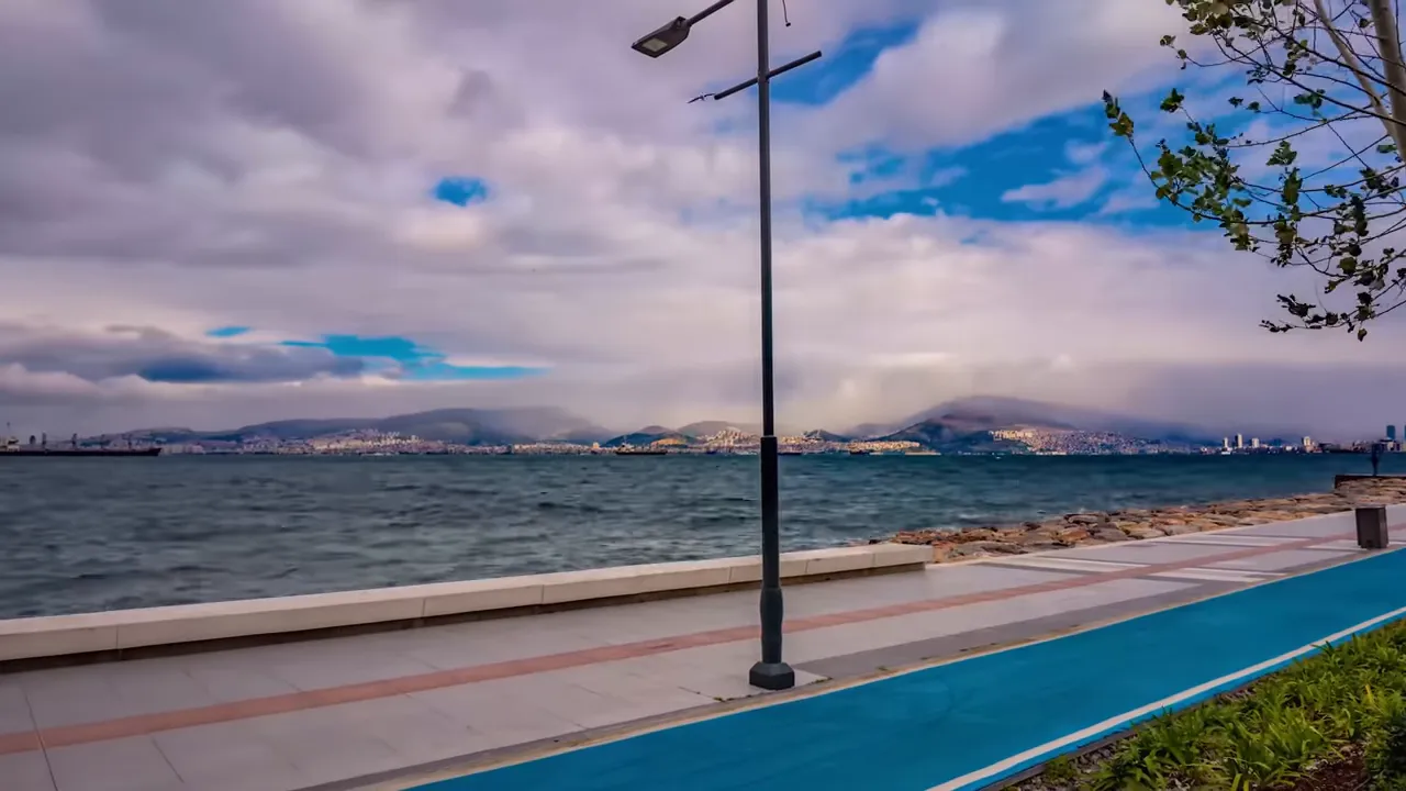 seafront promenade and bike lane along the Aegean with city skyline across the water